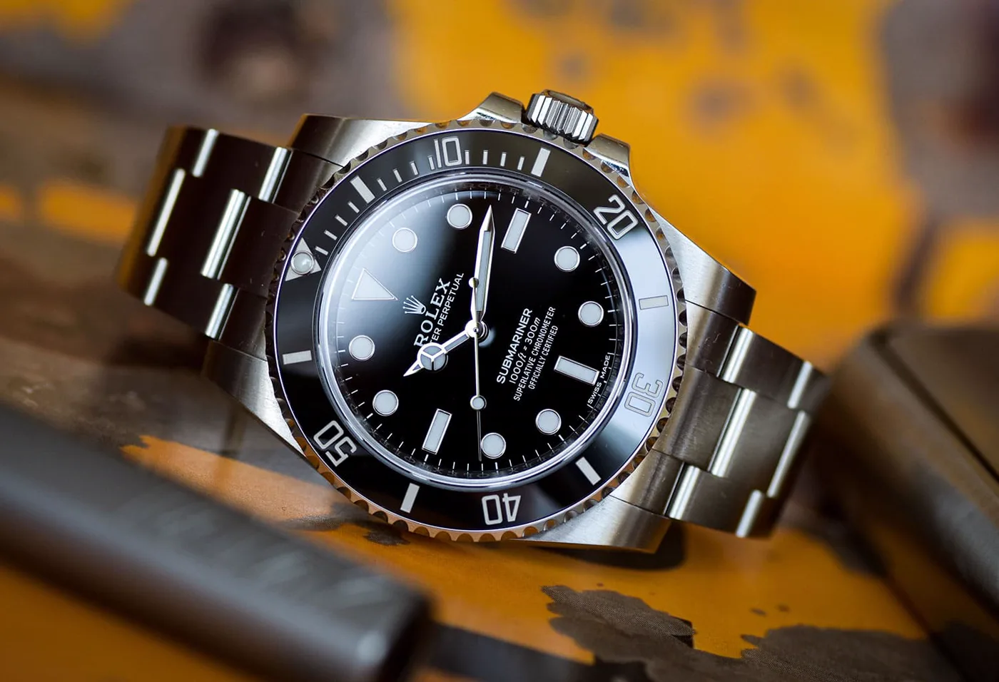 Rolex Submariner steel watch with black dial and bezel, resting on leather