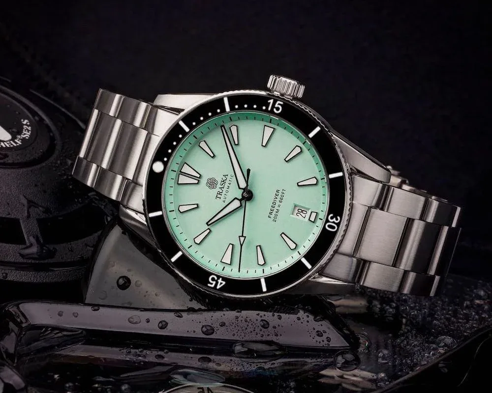 Traska Freediver watch with mint green dial, black bezel, and steel bracelet