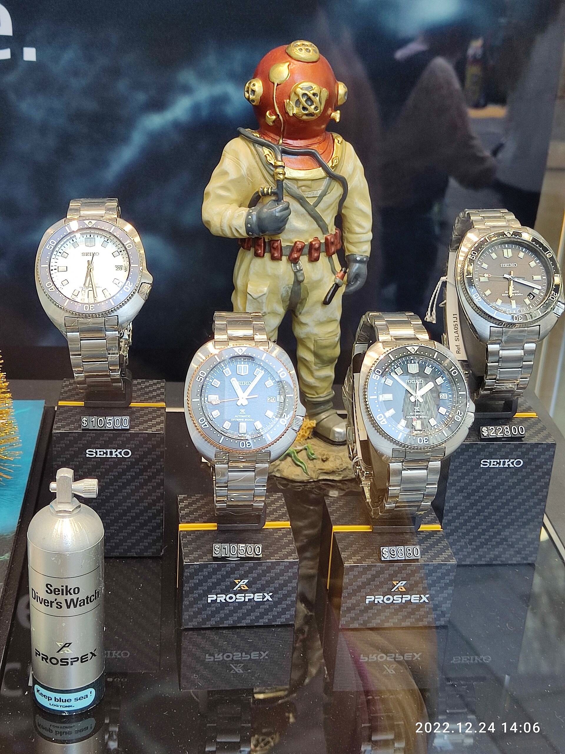A watch shop window display with rows of priced watches